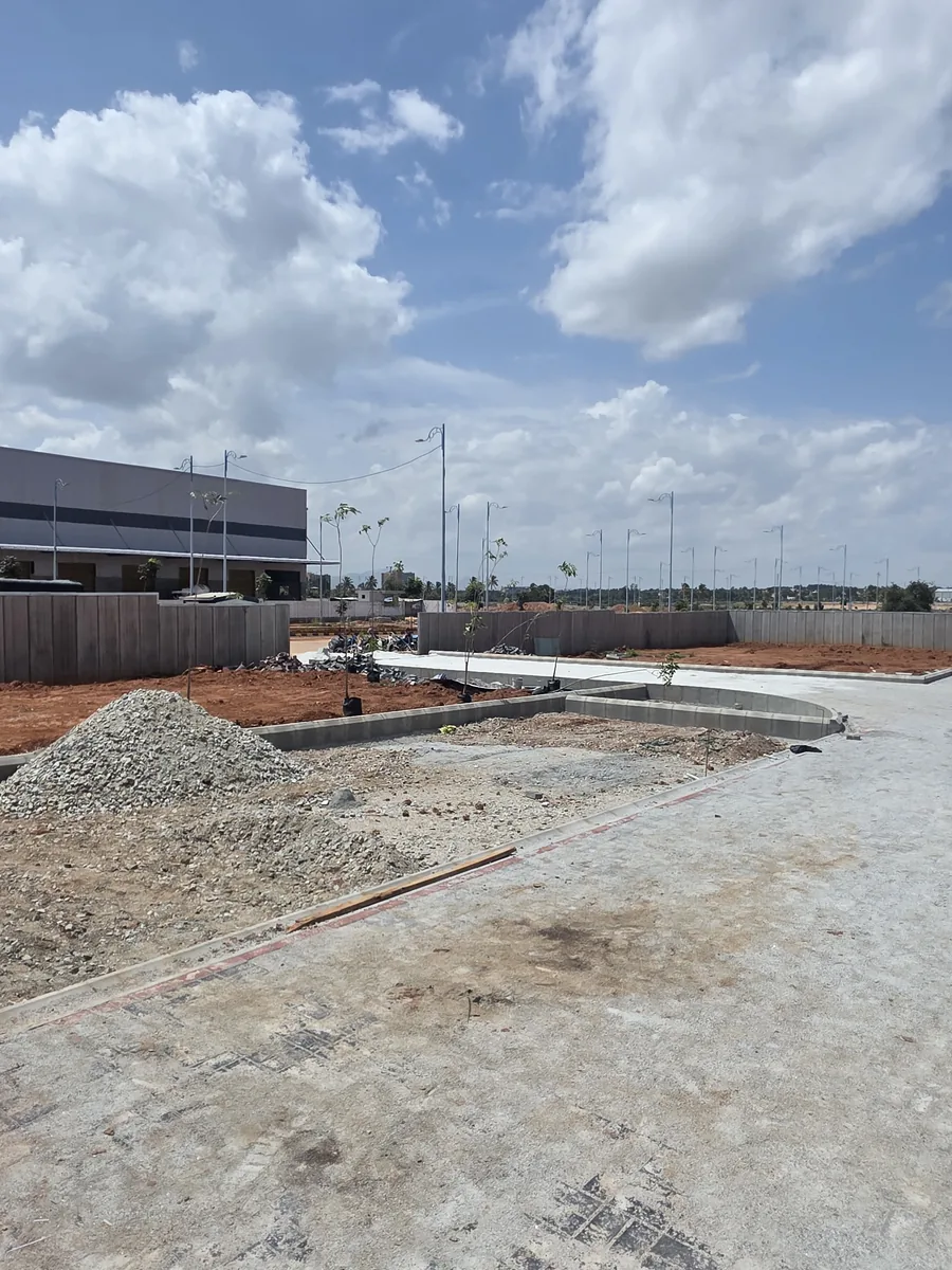 Curved planter kerbing, driveway paving and newly planted saplings under construction at Prestige Park Lane, Devanahalli, August 2026